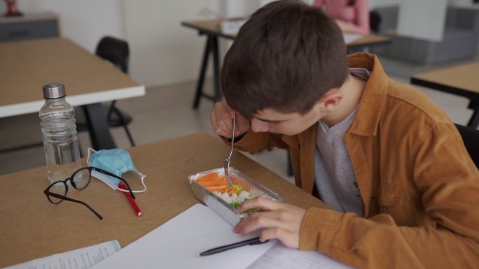 小男孩在教室午餐吃饭学校学生初中生