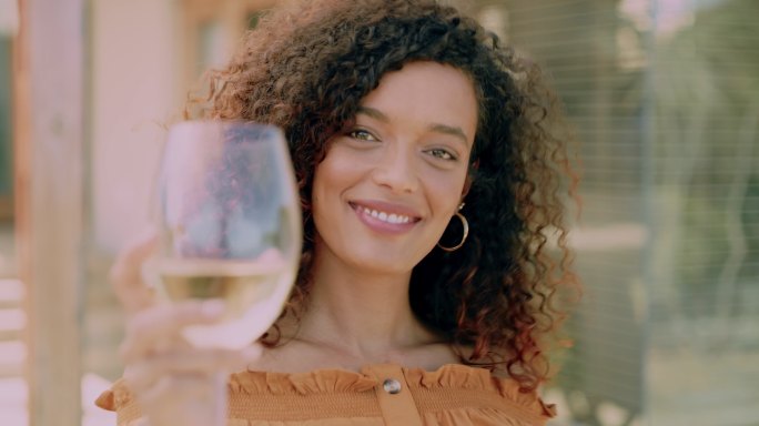一个漂亮的年轻女子在后院喝一杯葡萄酒