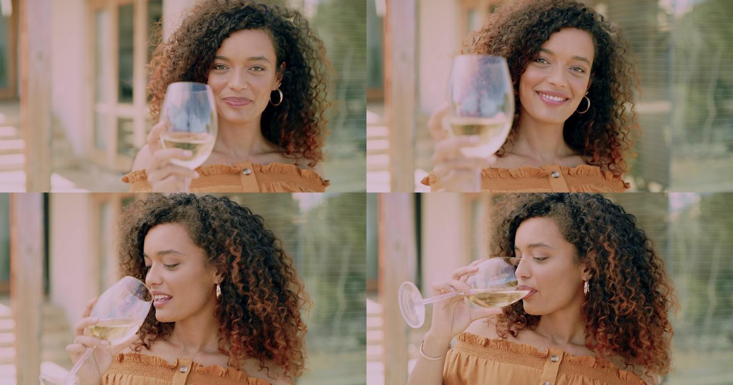 一个漂亮的年轻女子在后院喝一杯葡萄酒