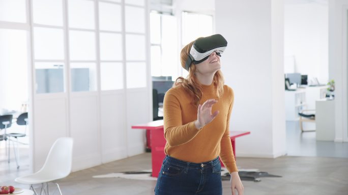 好奇的年轻女商人戴着VR护目镜