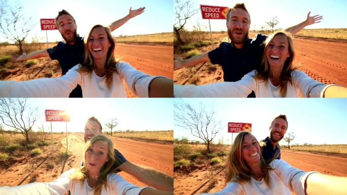 年轻夫妇站在骆驼警告牌旁自拍