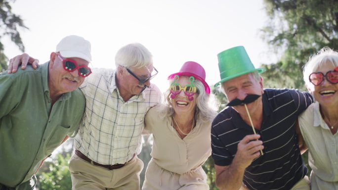 公园里一群戴着有趣眼镜和帽子的快乐老人