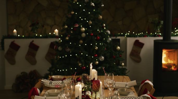 家庭圣诞晚餐前整齐摆放的餐桌和圣诞树