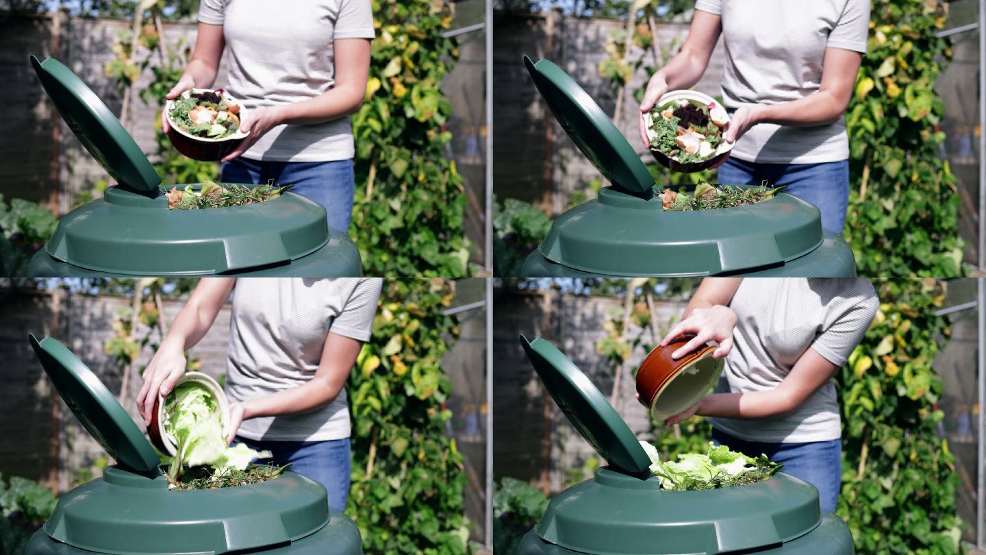 妇女把食物垃圾倒进花园堆肥机