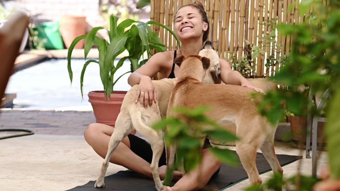 一名年轻女子在家做瑜伽后与她的狗玩耍