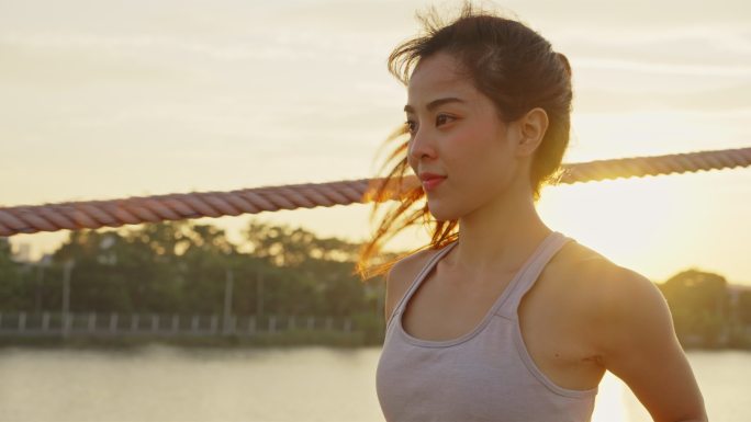 一位年轻美丽的女子在公园的桥上跑步