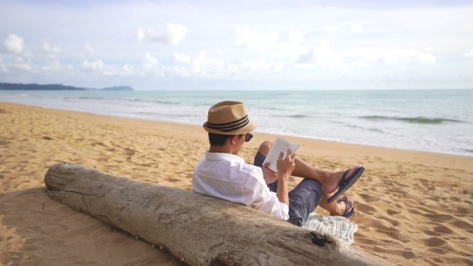 在沙滩上看书的男人
