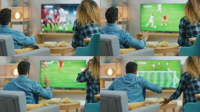 年轻夫妇在电视上观看足球比赛