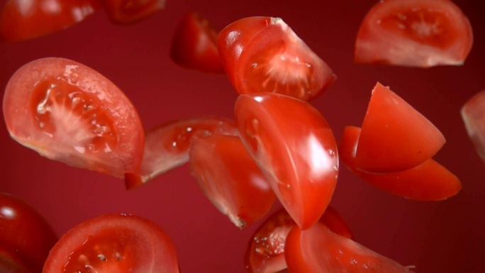 红色成熟多汁的番茄片在红色背景上飞扬