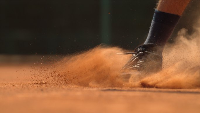 网球运动员的腿在地上滑行，超慢动作