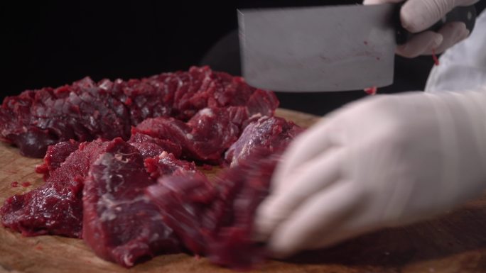 原木砧板上剔肉切除牛肉的脂肪和肉筋