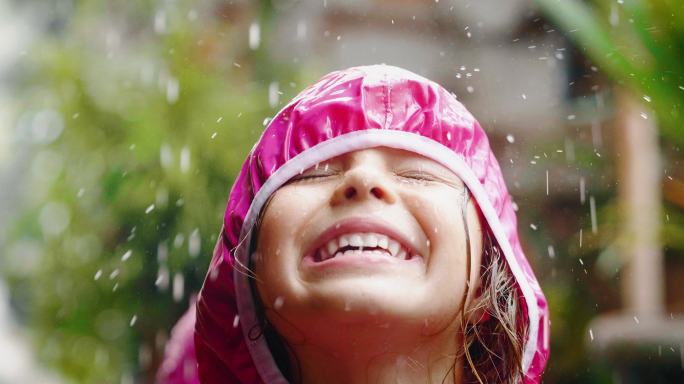一个快乐的女孩在雨中玩耍