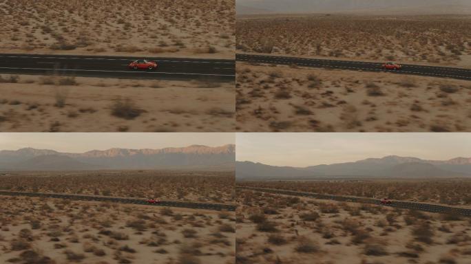 红色经典轿车沿着荒凉的沙漠公路行驶