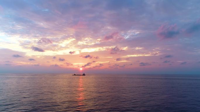 清晨夕阳下大海上航行的货船唯美的海面