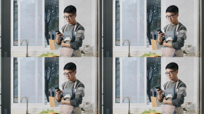 4K年轻男性在厨房玩手机特写