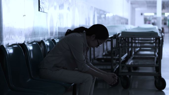 一名妇女独自坐在医院里。