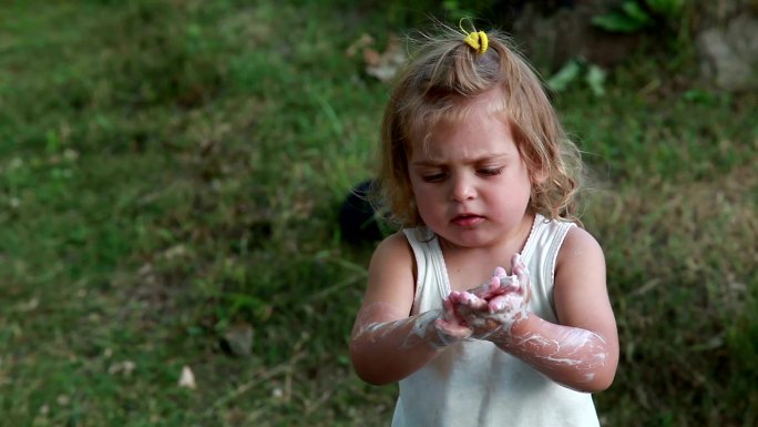 小女孩露出肥皂水般的手