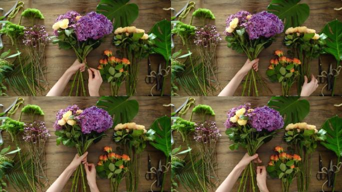 花店妇女手持鲜花制作花束俯视图