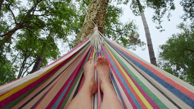 在森林吊床上的脚树放松快乐