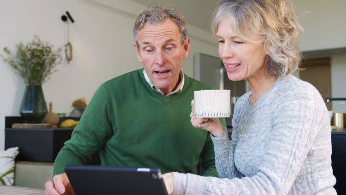 老年夫妇在家使用数字平板电脑在线购买产品