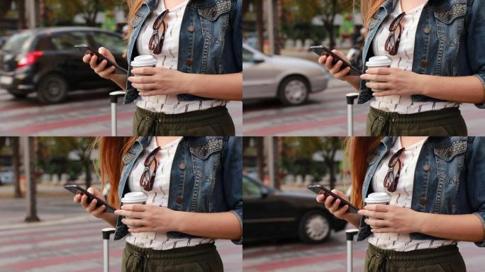 年轻漂亮的女人站在人行道上用手机找出租车