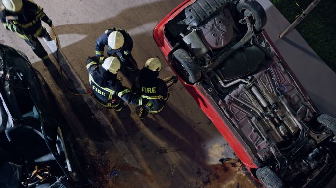 消防队员在夜间用液压吊具打开一辆车门