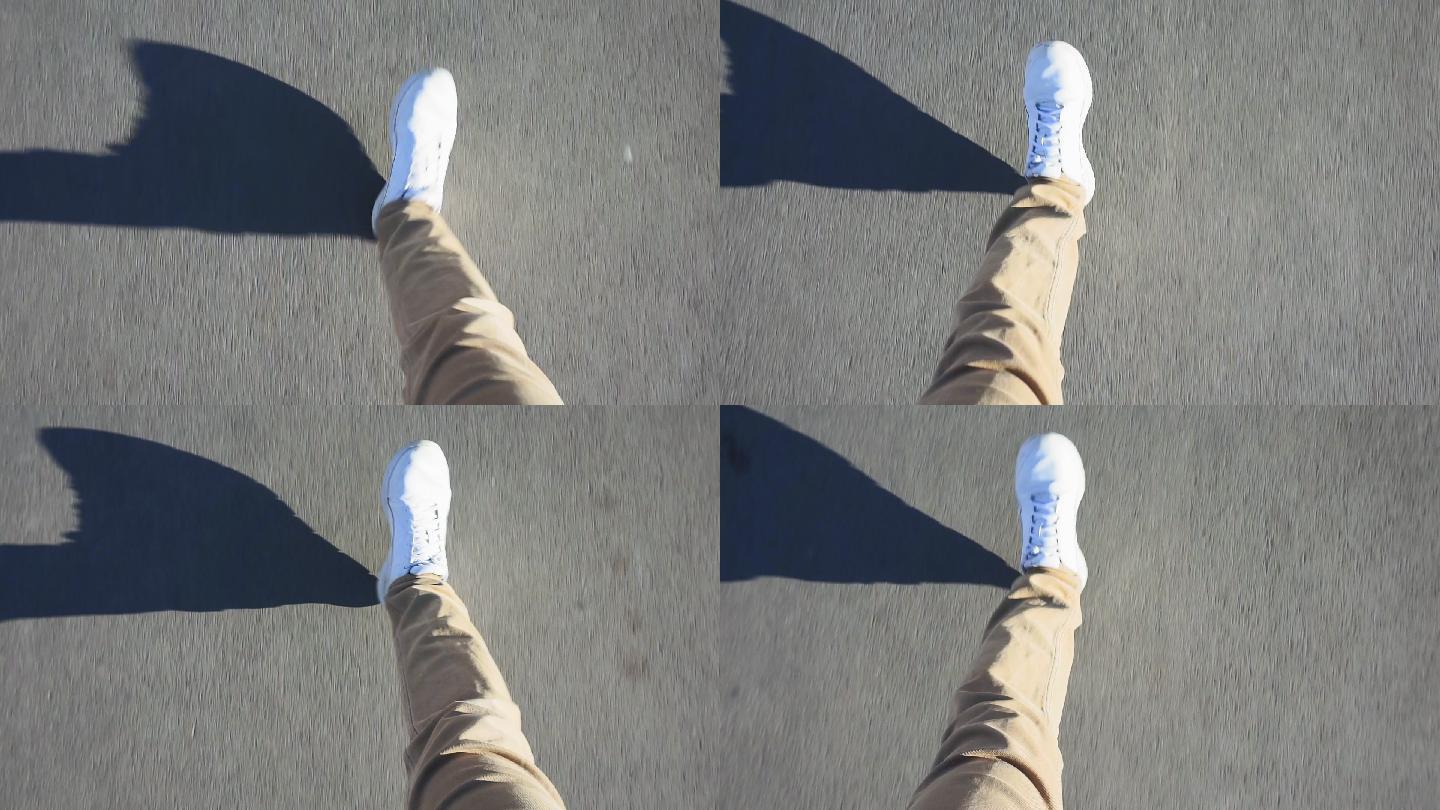 一名男子穿着白色运动鞋在人行道上行走