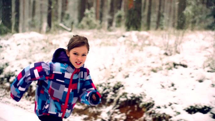 一个女孩在冬季森林的雪地里慢跑