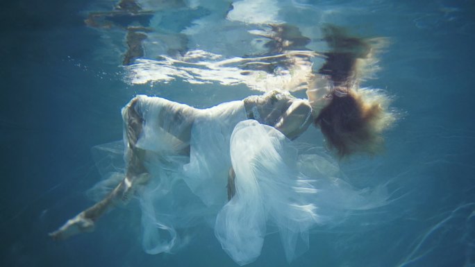 金发女郎漂浮在美丽神秘的水下世界。