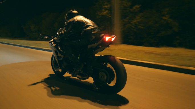 摩托车手在夜色中驾驶摩托车。
