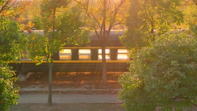 夕阳下的乡愁公园火车列车在金黄色光辉航拍