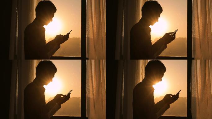 日落时用手机的男人