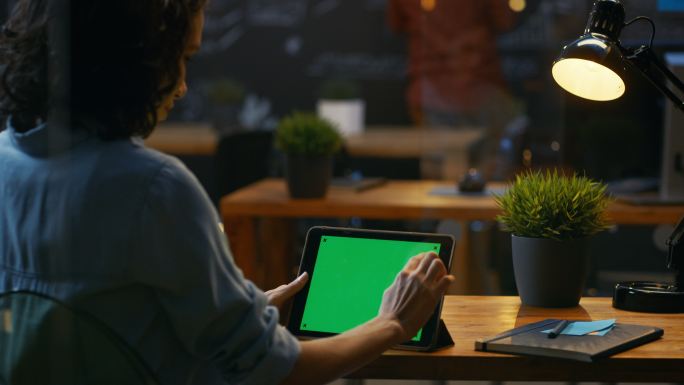 年轻女士使用绿屏平板电脑