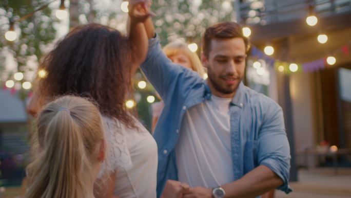 情侣和一群朋友一起在花园派对上跳舞