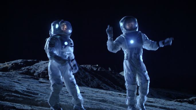 男宇航员和女宇航员穿着宇航服在外星球表面跳舞。