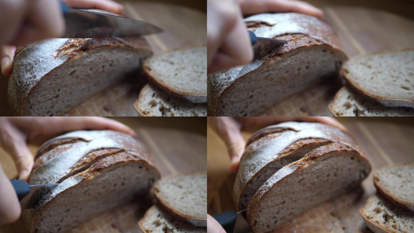 特写镜头：双手在木板上用锋利的小刀切面包