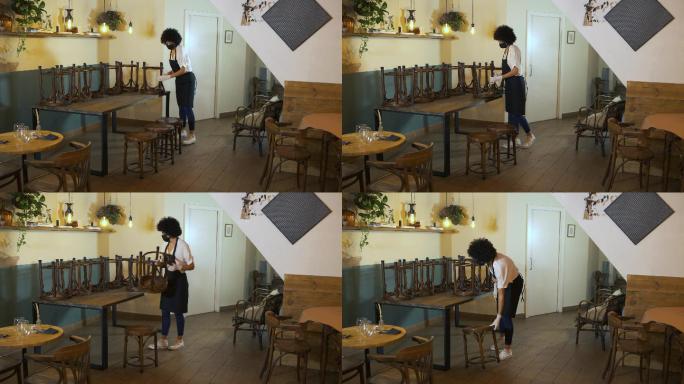 年轻的女店主在咖啡店里摆好桌椅。
