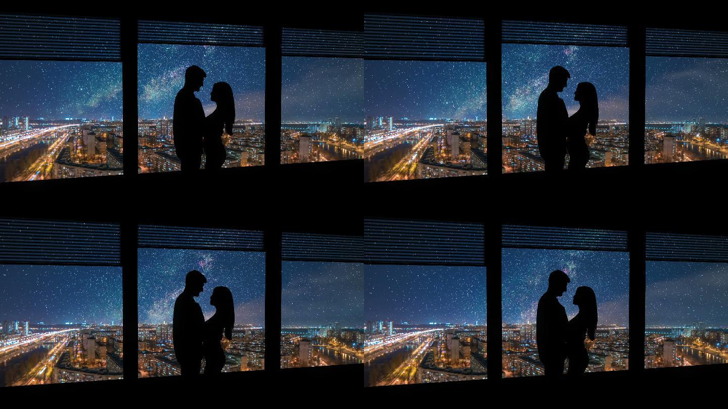这对男女站在一扇有夜市背景的窗户附近