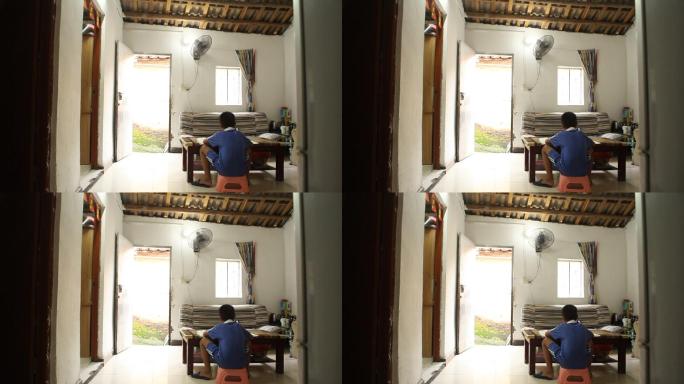 小学生在简陋的屋子里做作业