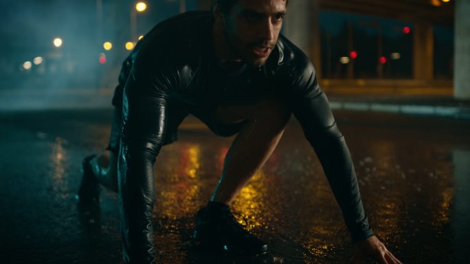 一个年轻人在一个下雨的晚上开始短跑。