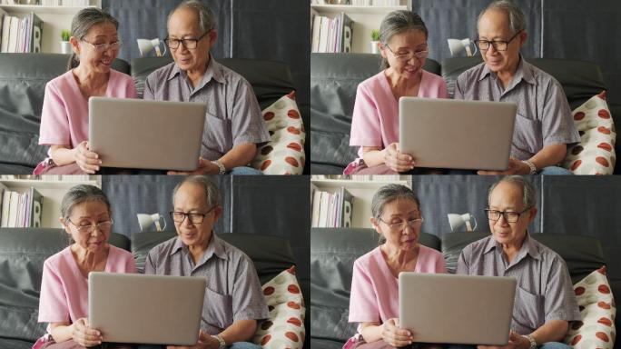 老年夫妇在家用笔记本电脑上网