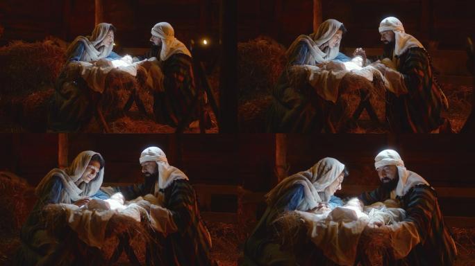 玛丽和约瑟夫在发光的马槽里爱抚着小耶稣