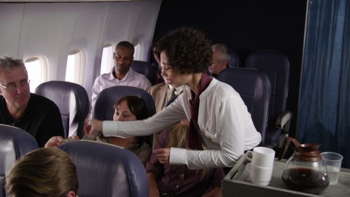 为航班乘客提供饮料的空姐