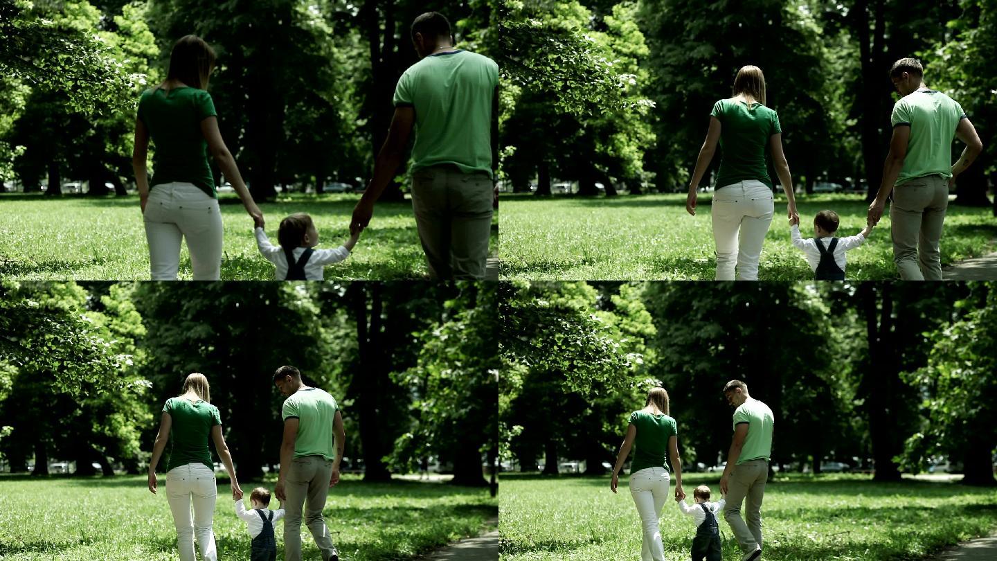 一家人在公园散步年轻的家庭爱的情感父母