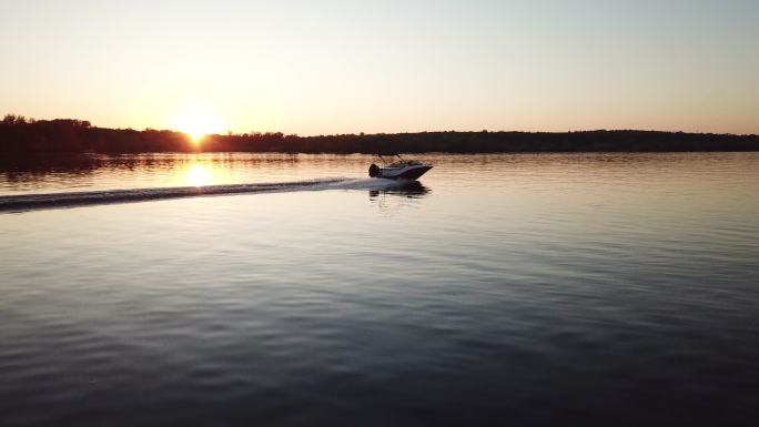 在美丽的金色夕阳下，摩托艇漂浮在河上