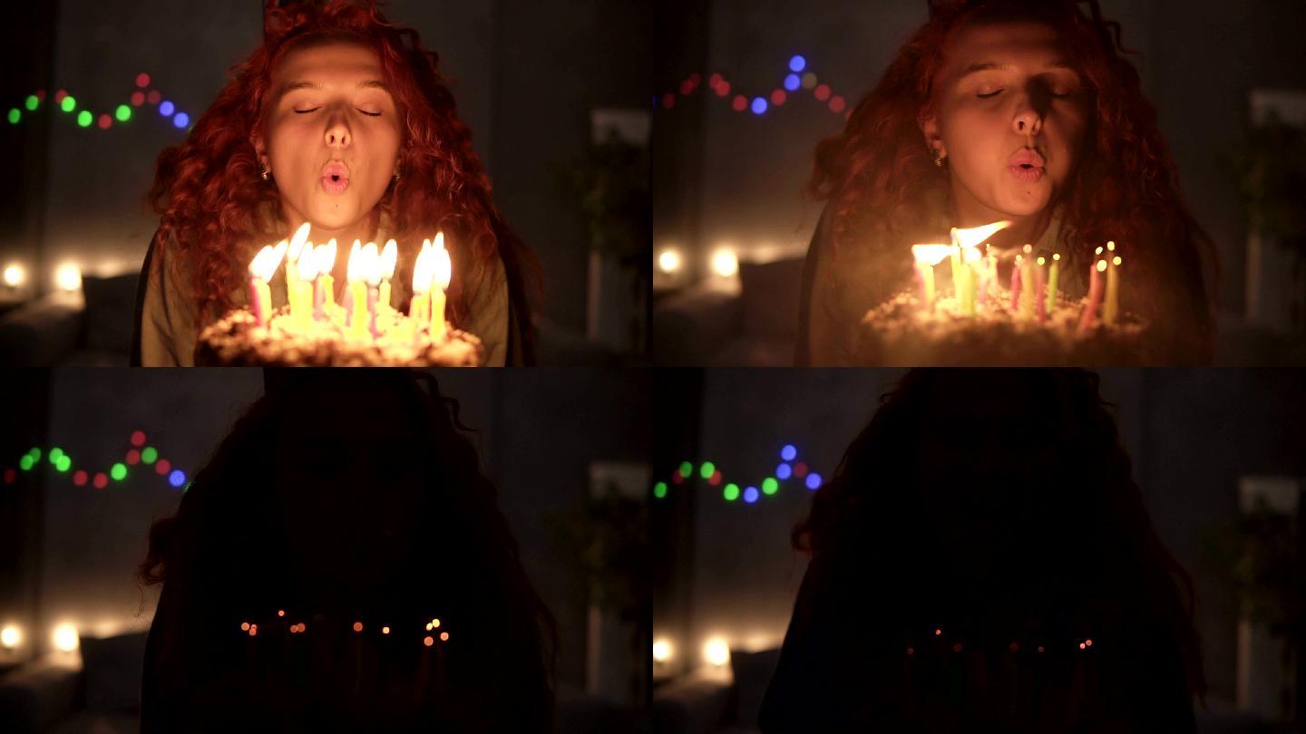 红色卷发女孩许愿并吹灭生日蛋糕上的蜡烛