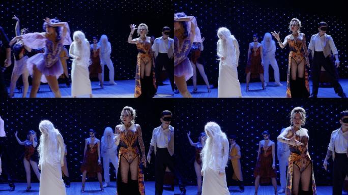 美丽的火女孩在剧院舞台上与男生一起歌唱