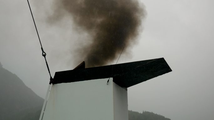 从船上的管道向外释放黑烟到空气中，污染了空气