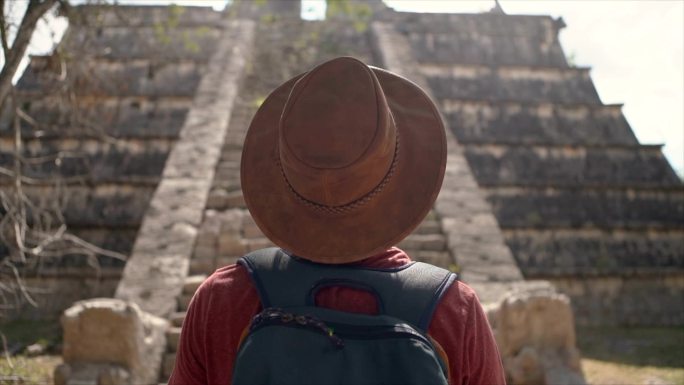 戴帽子的男子看着墨西哥的古玛雅神庙