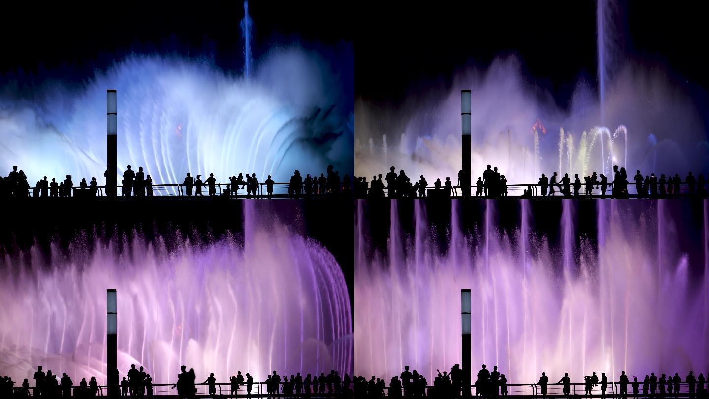 夜晚看喷泉的人彩色喷泉